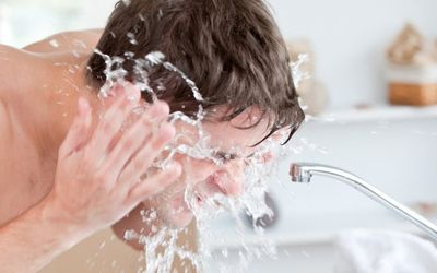 мужчина умывается холодной водой